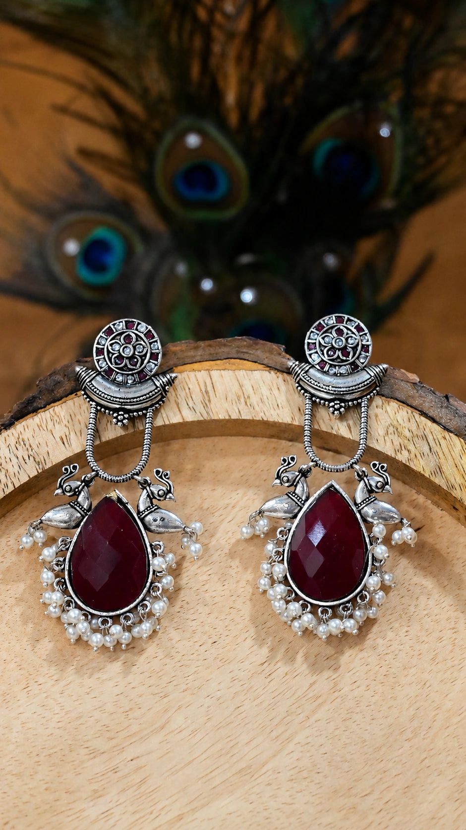 Close-up ear view showing maroon accents, bird motifs and pearl drops