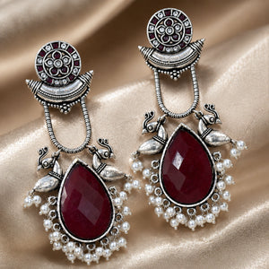 Close-up of maroon accents, pearl-style beads and engraved bird motifs