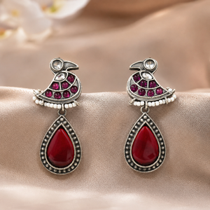 Close-up of maroon accents, bird motifs and pearl-style dangle detailing
