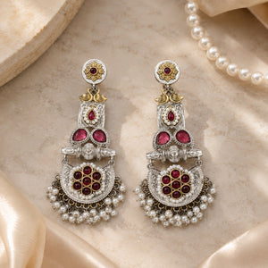 Angled view of German silver maroon pearl chandelier earrings