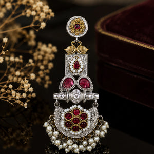 Maroon pearl chandelier earrings on a dark jewellery studio display
