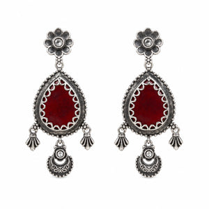 Maroon teardrop floral dangle earrings on a dark jewellery studio display