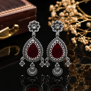 Close-up of maroon teardrop stones and German silver floral detailing