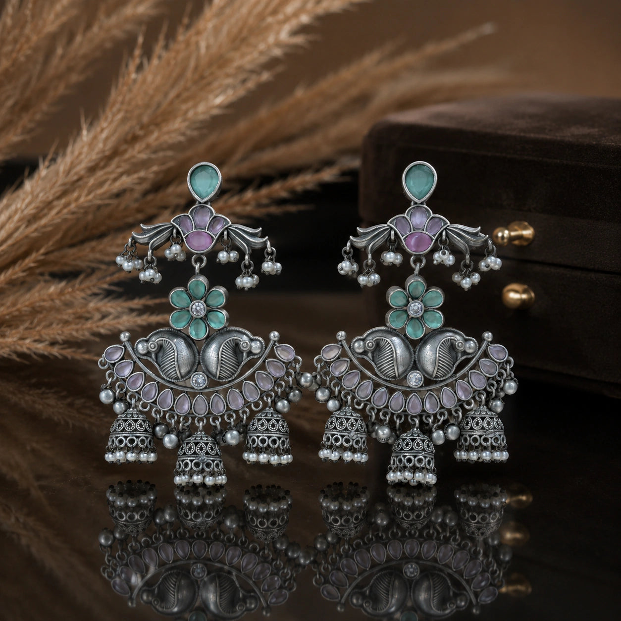 Mint purple pearl chandelier earrings on a dark jewellery studio display
