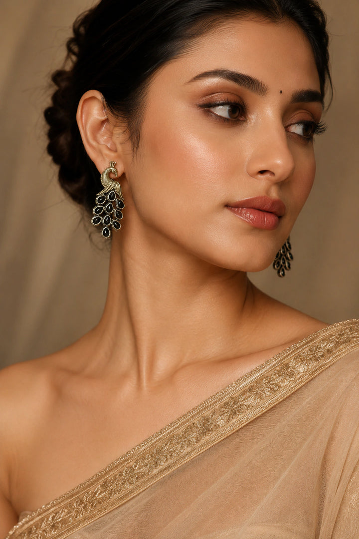 German silver navy crystal-style peacock chandelier earrings worn by a model
