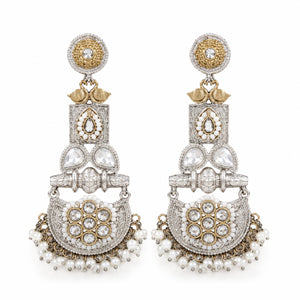 Pearl-style crystal chandelier earrings on a dark jewellery studio display