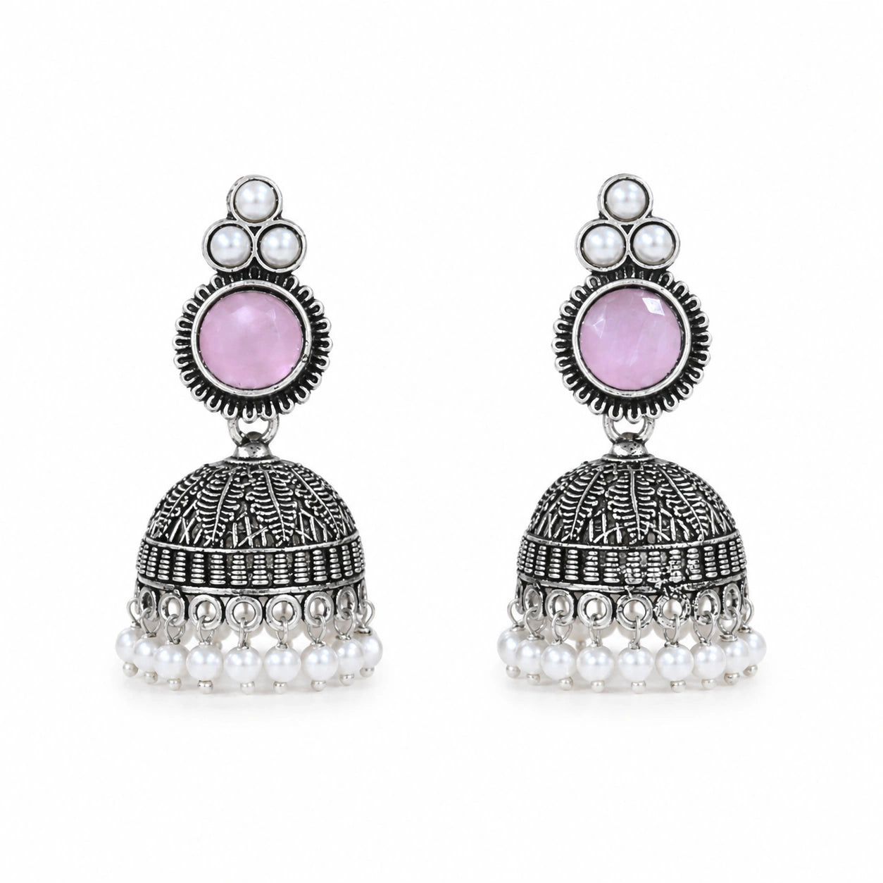 Pink pearl-style jhumka earrings on a dark jewellery studio display