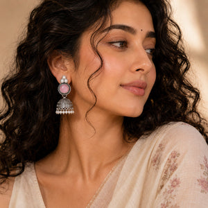 Pink pearl-style jhumka earrings styled in an elegant jewellery flat lay