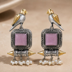 Angled view of German silver pink-stone bird pearl dangle earrings