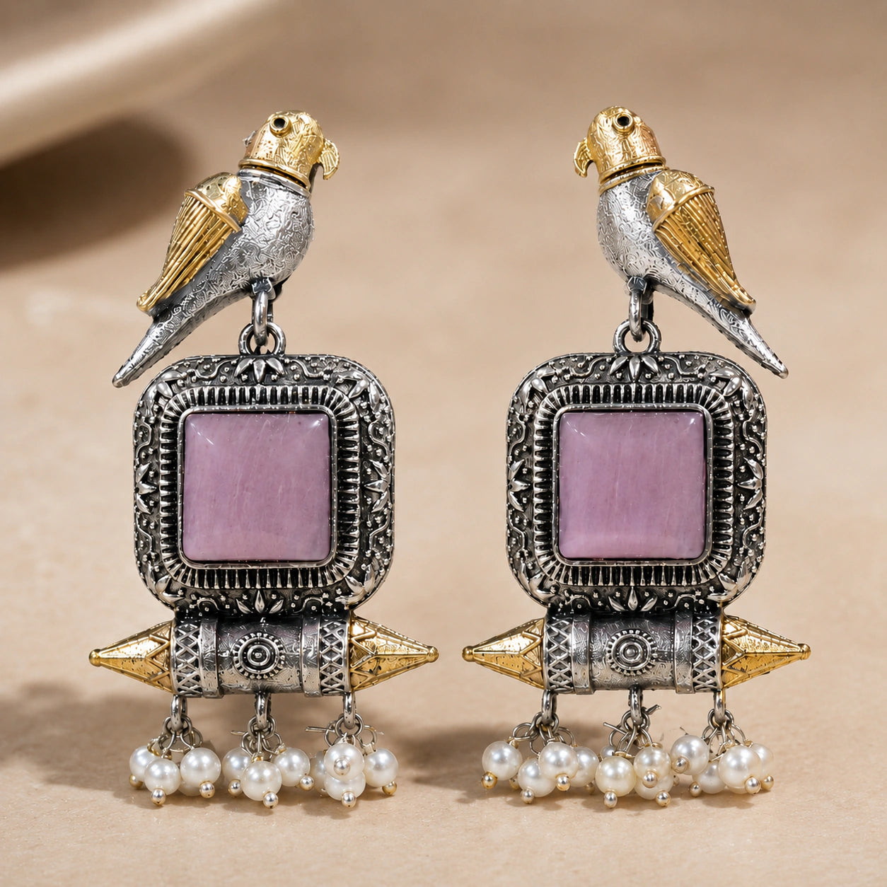Angled view of German silver pink-stone bird pearl dangle earrings