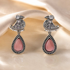 Close-up of pink teardrop stones, bird motifs and pearl-style drops