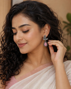 German silver pink teardrop bird pearl-style earrings worn by a model