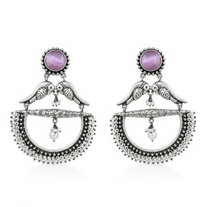 Close-up of purple accents, bird motifs and pearl chandelier detailing