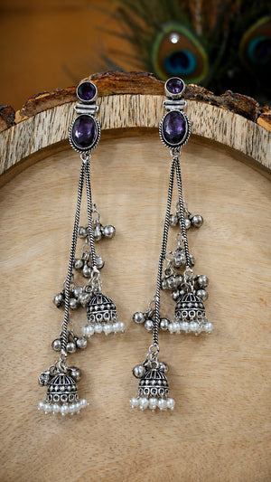 Close-up ear view showing purple accents, pearl drops and chandelier layers