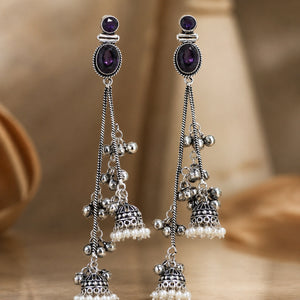 Close-up of purple crystal-style accents, pearl drops and chandelier detailing