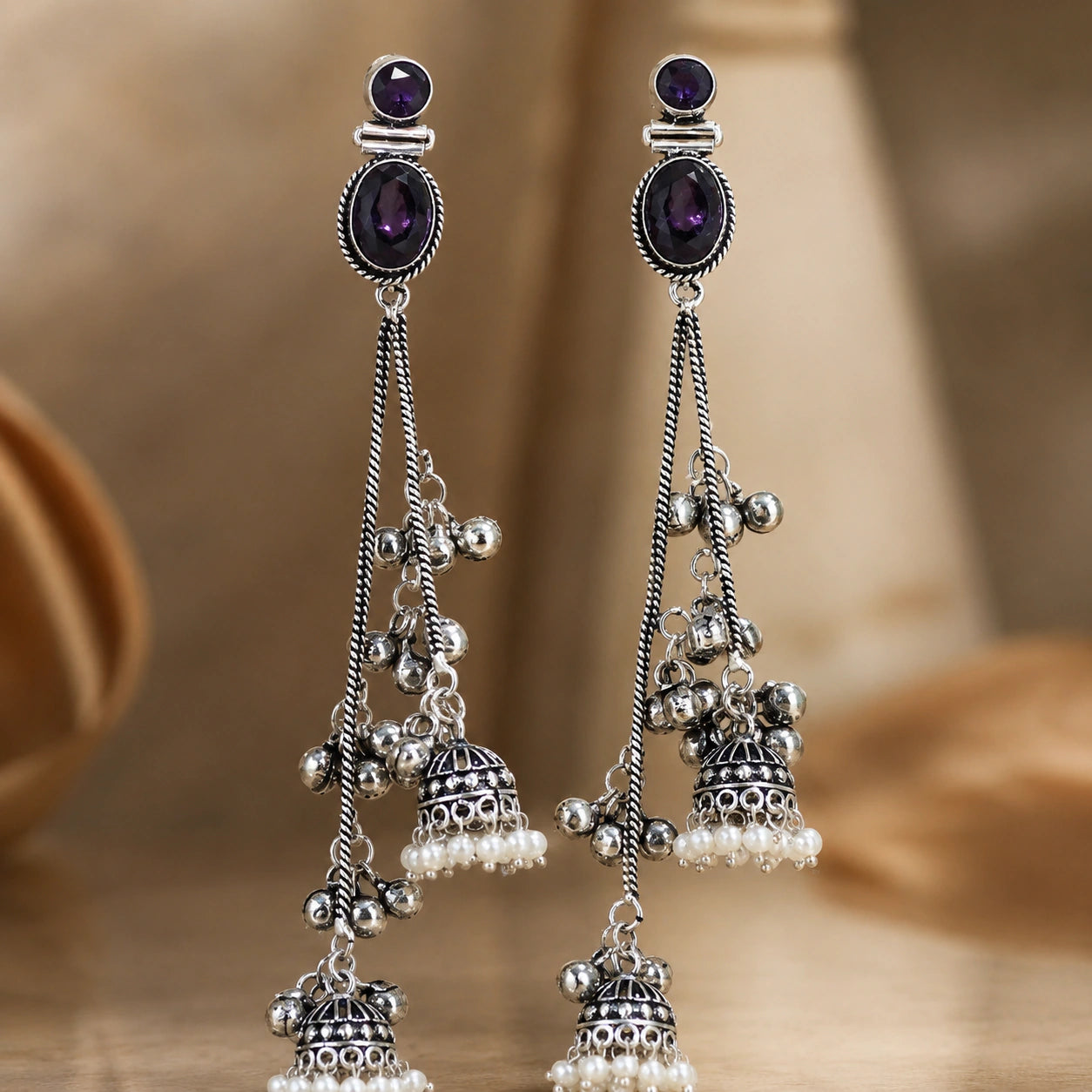 Close-up of purple crystal-style accents, pearl drops and chandelier detailing