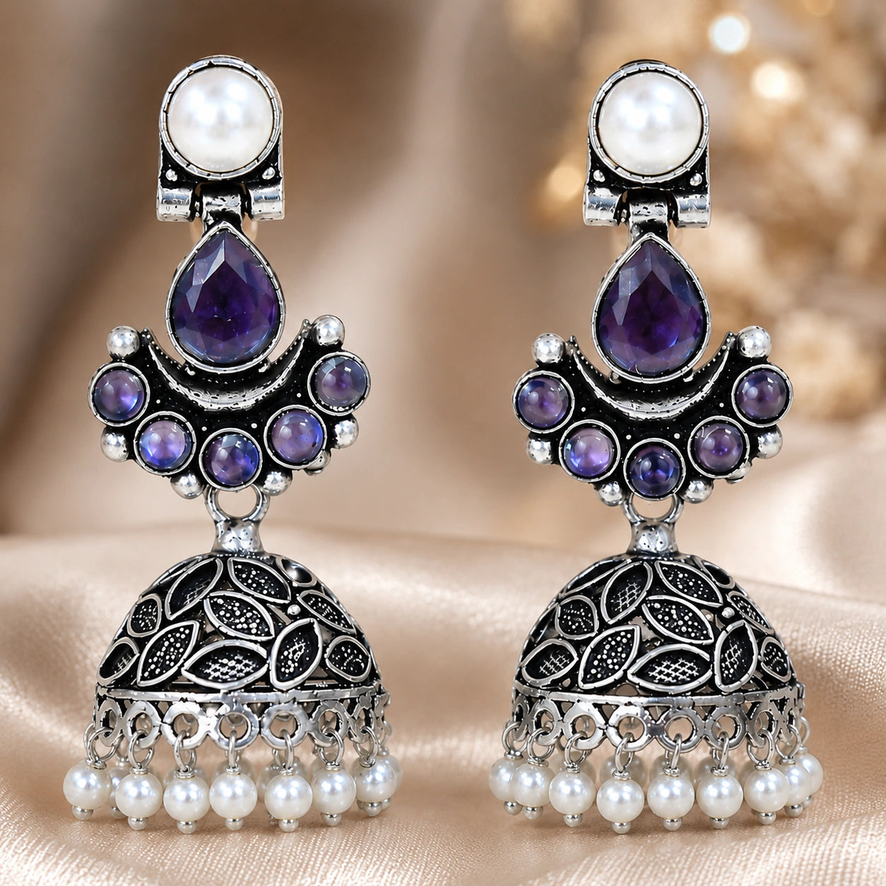Purple pearl leaf dome jhumka earrings styled in an elegant jewellery flat lay