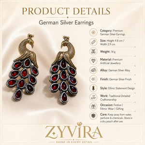 Red peacock chandelier earrings on a glossy dark reflective jewellery display