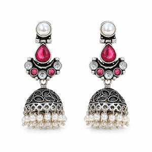 Angled view of German silver ruby-tone pearl leaf jhumka earrings