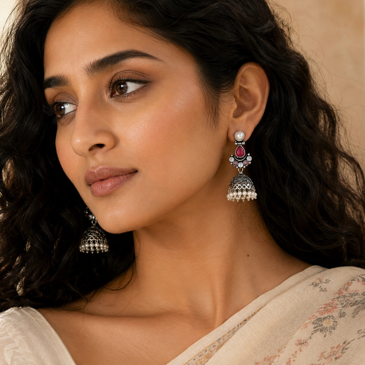Close-up of ruby-tone stones, leaf motifs and pearl-style jhumka detailing