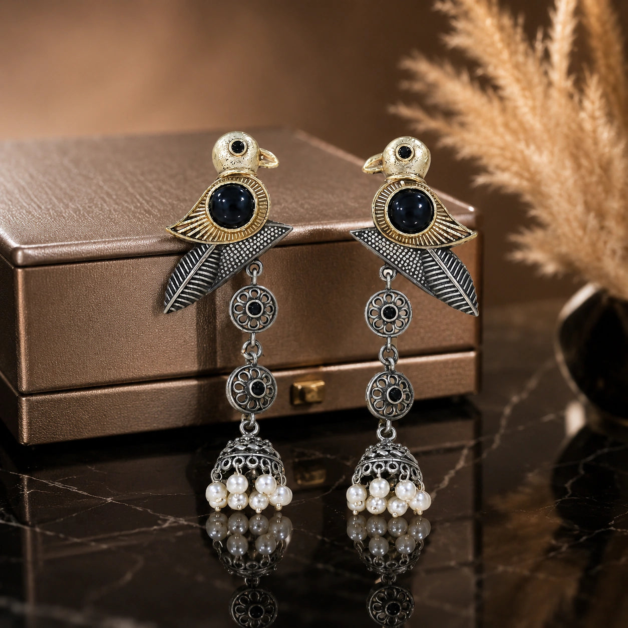 Sparrow pearl dangle earrings on a dark jewellery studio display