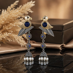 Sparrow pearl-style jhumka earrings on a glossy dark reflective jewellery display