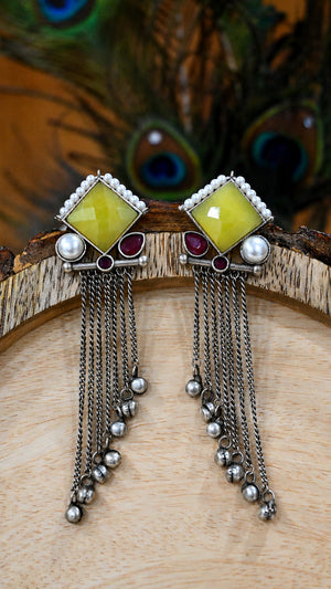 Close-up ear view showing the layered yellow, maroon and pearl-style fringe