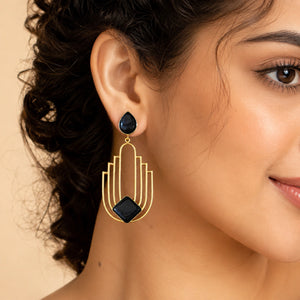 Gold black geometric earrings styled in a modern jewellery flat lay
