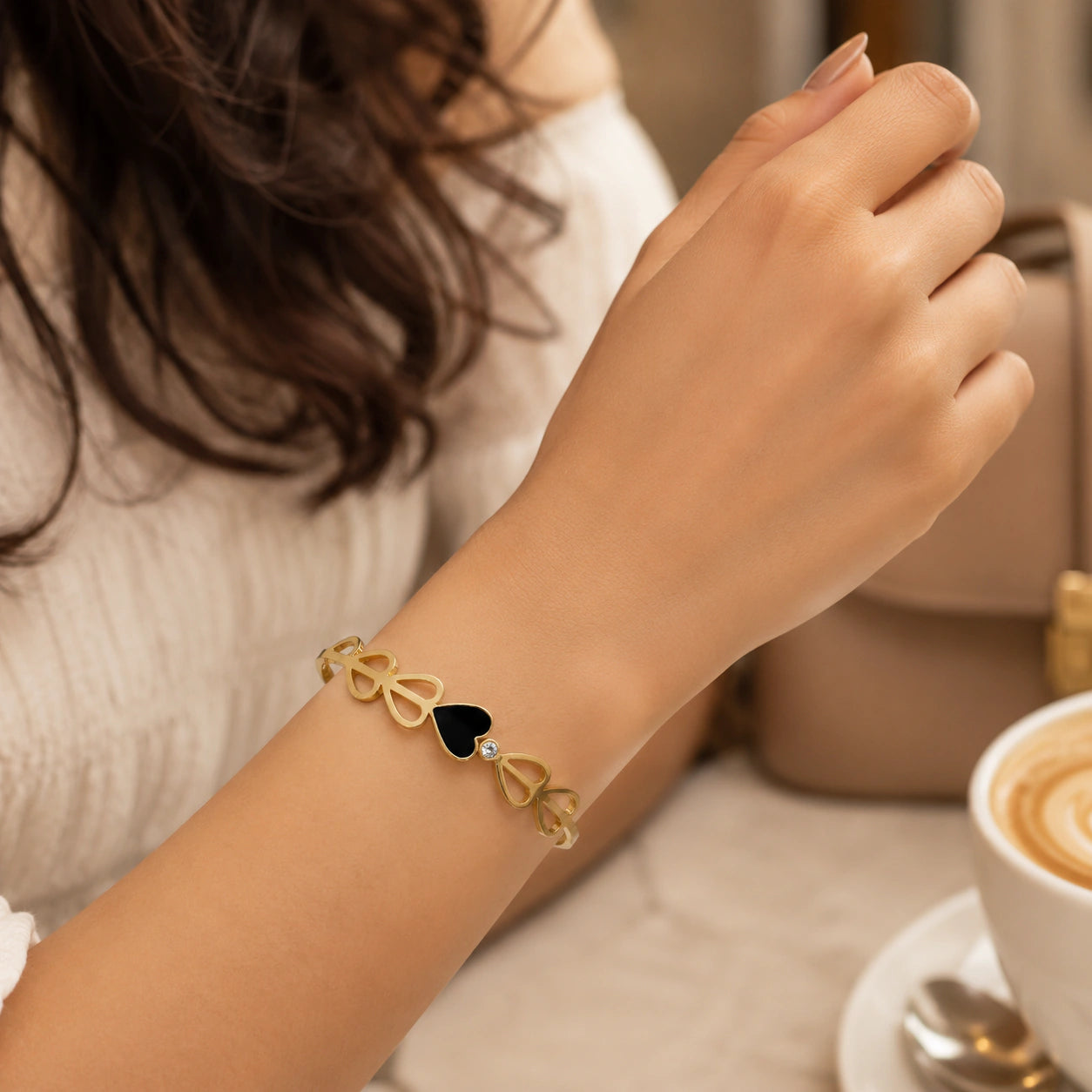 Angled view of the gold black-heart crystal cutout kada