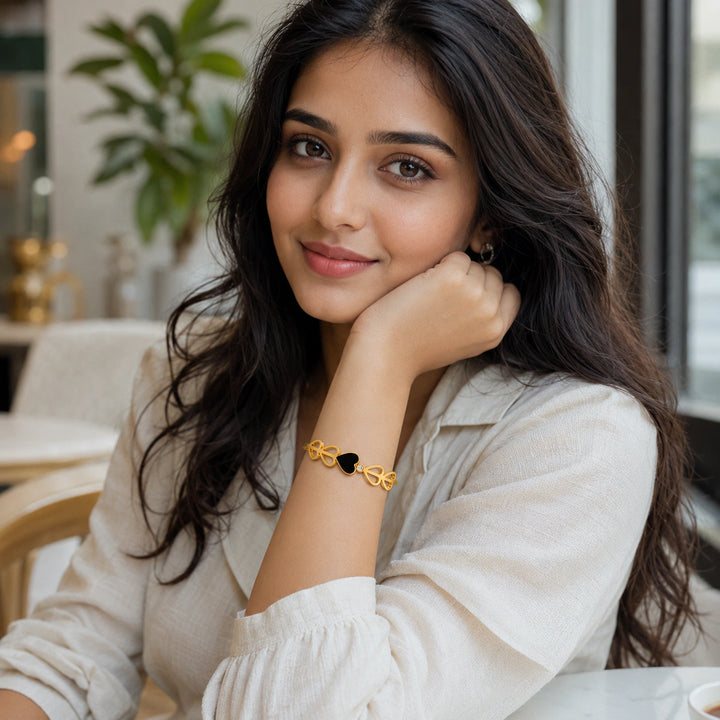 Gold black-heart crystal cutout kada on a dark jewellery studio display