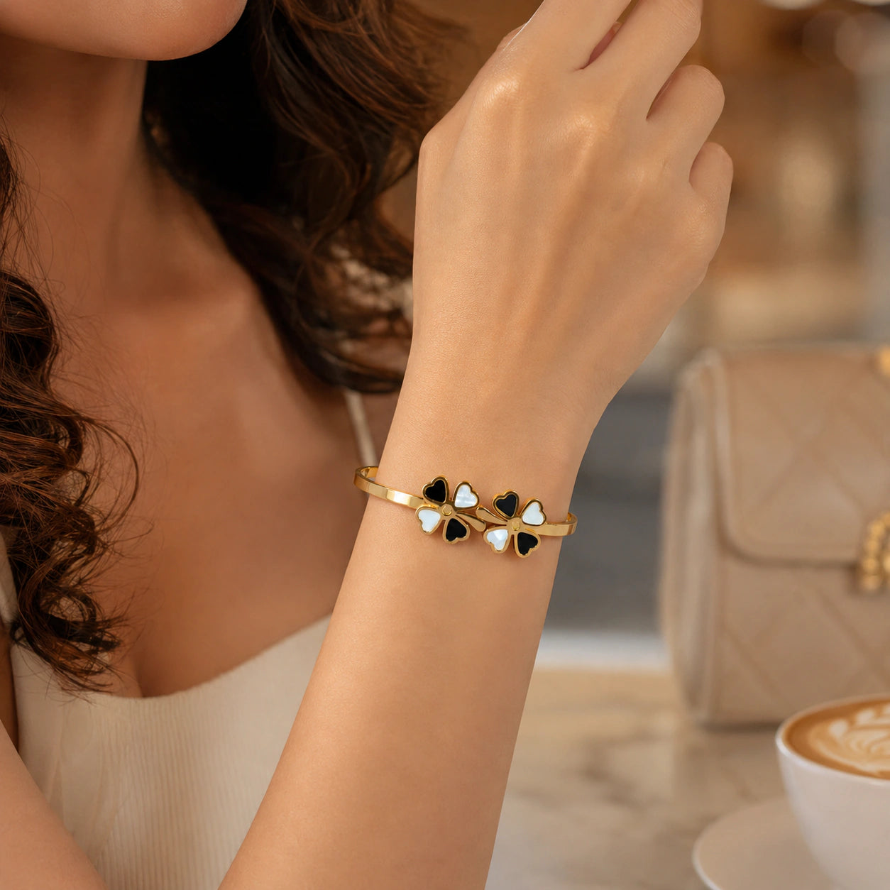 Top view of the gold black pearl-style clover kada