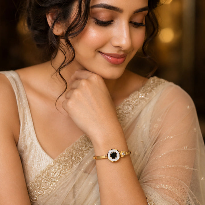Gold black-centre pearl-style halo kada on a dark jewellery studio display