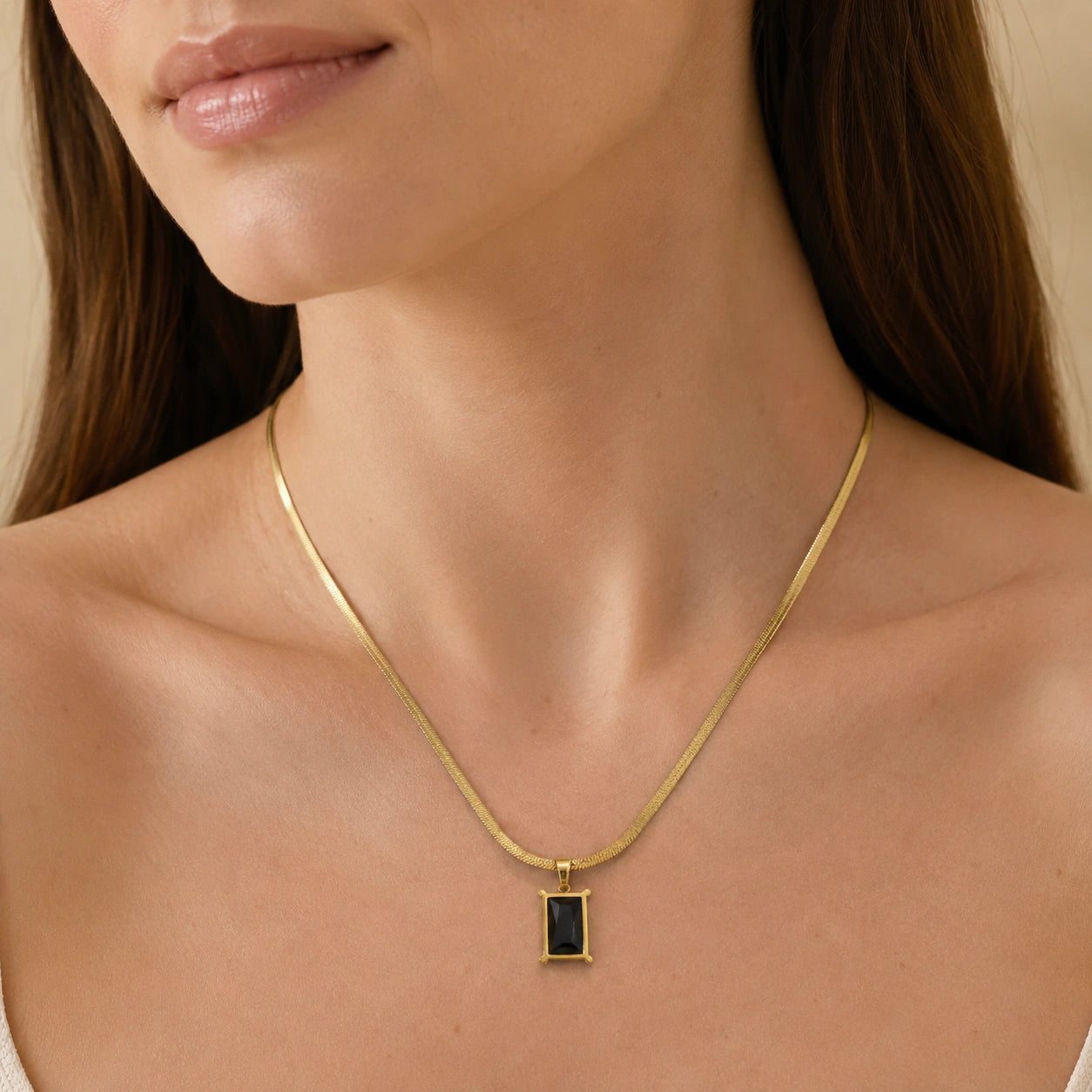 Close-up of the black rectangular stone and snake-chain detailing