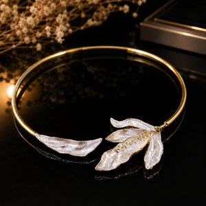 Gold blush floral collar Hasali on a dark jewellery studio display