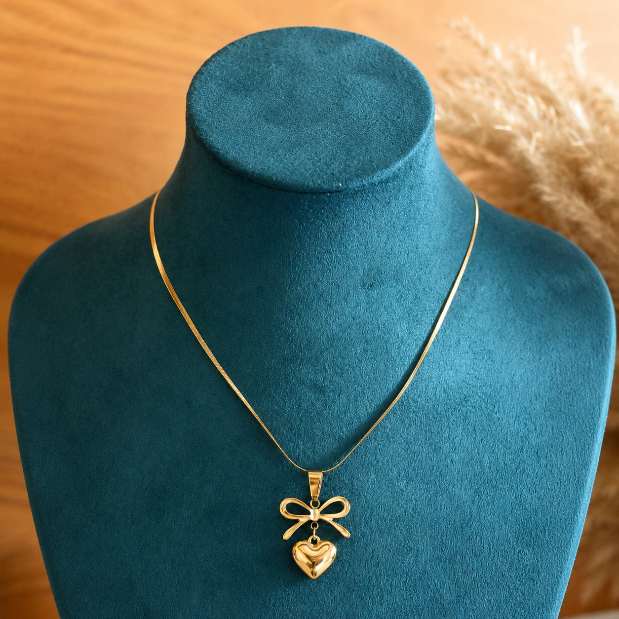 Alternate detail view of the gold bow heart pendant