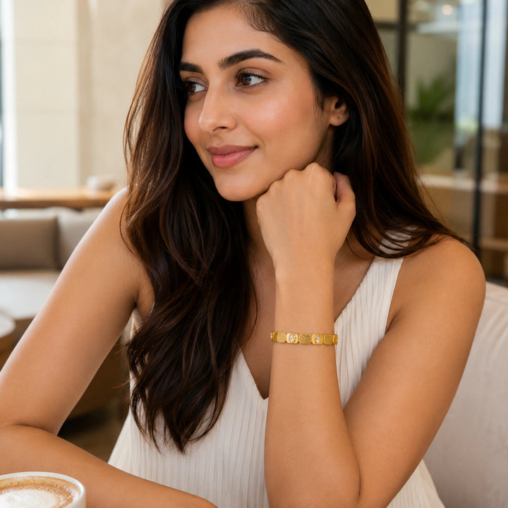 Gold brushed link crystal kada on a dark jewellery studio display
