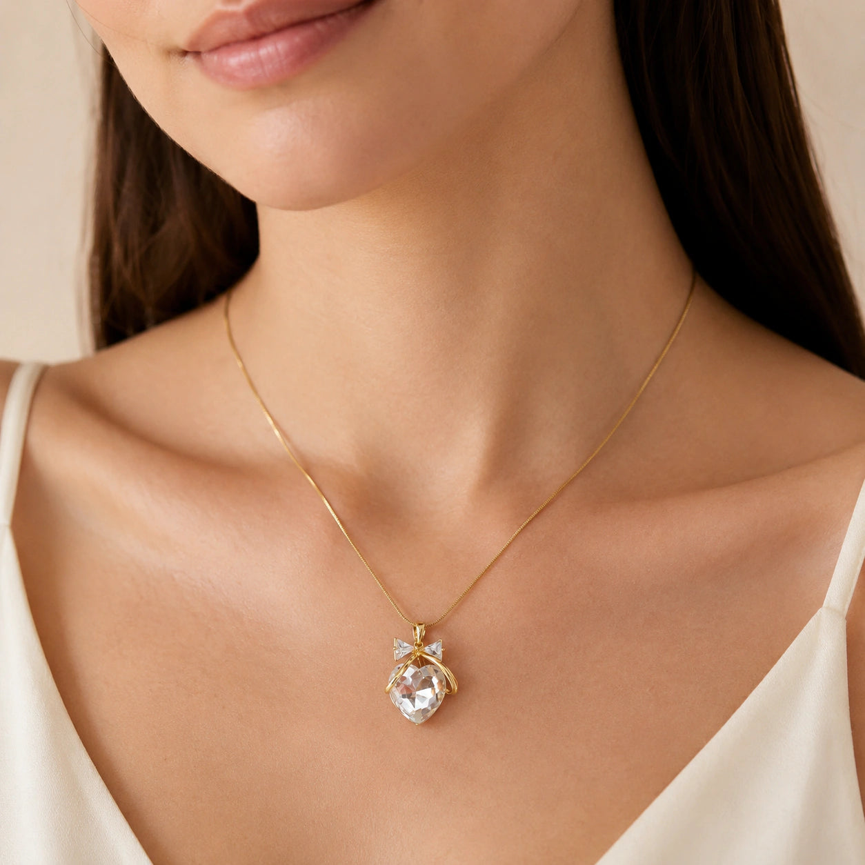 Gold heart bow necklace styled in an elegant jewellery flat lay