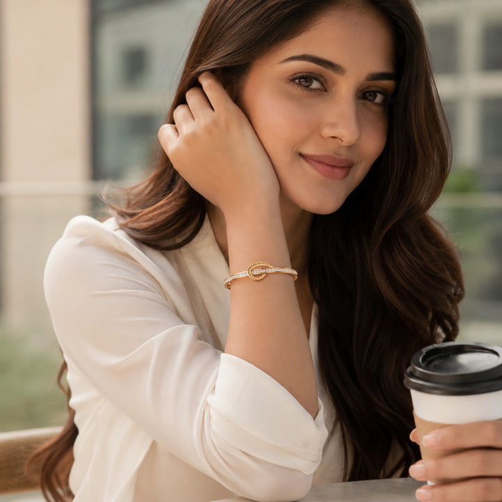 Gold crystal leaf knot kada on a dark jewellery studio display