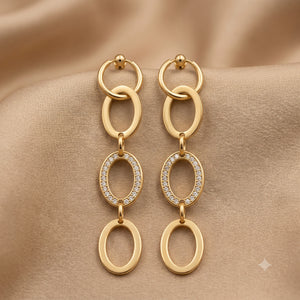 Gold oval-link statement earrings styled in an elegant jewellery flat lay