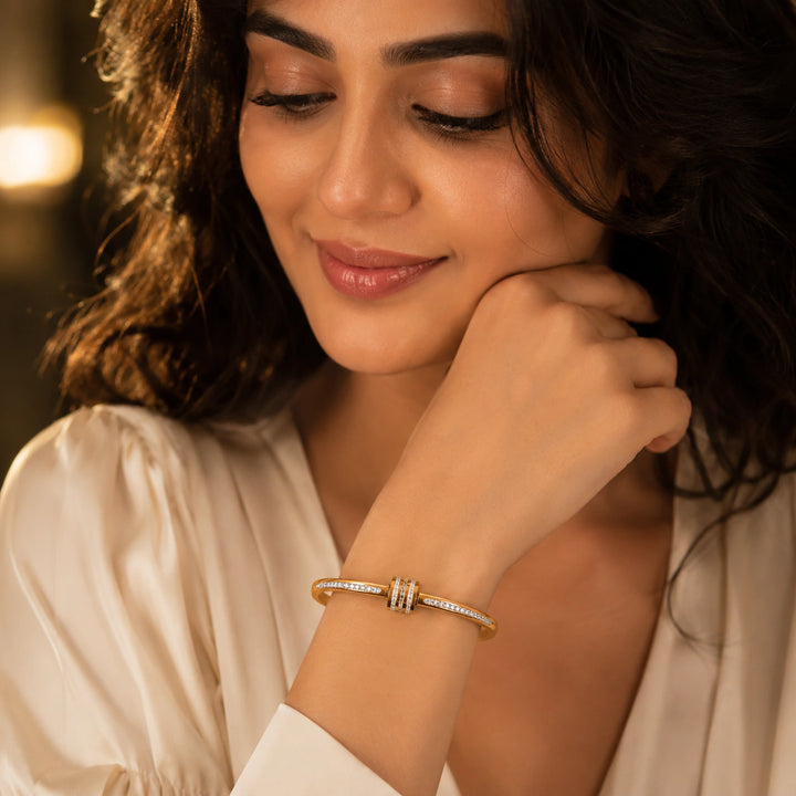 Gold crystal teardrop layered kada on a dark jewellery studio display