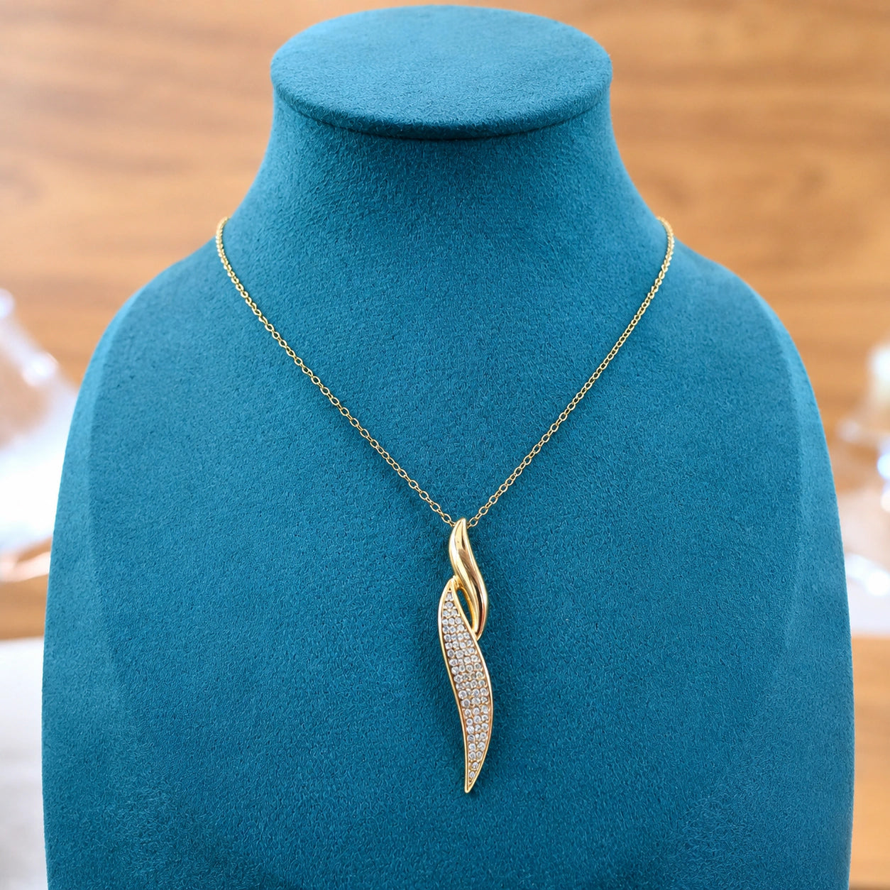 Alternate detail view of the gold curved crystal twist pendant
