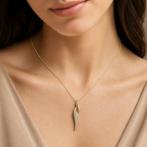 Gold curved crystal twist necklace on a dark jewellery studio display