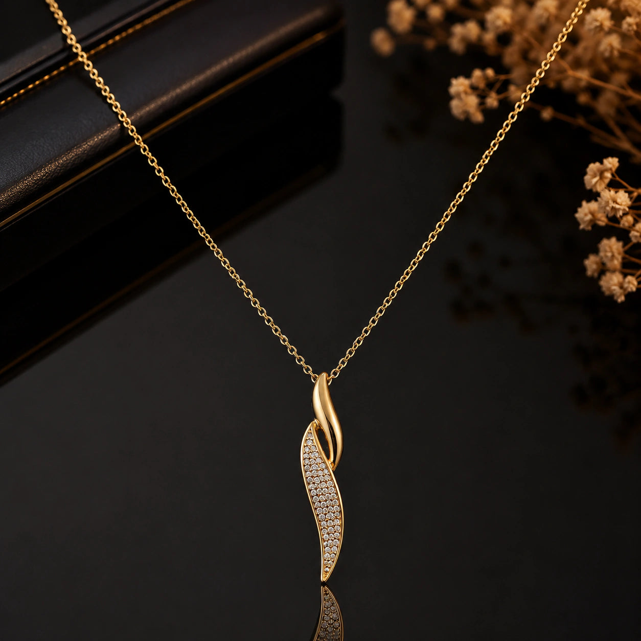 Gold curved twist necklace styled in an elegant jewellery flat lay