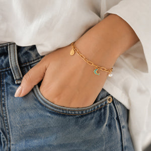 Side view of the gold dolphin pearl charm bracelet