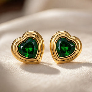 Gold emerald heart studs styled in an elegant jewellery flat lay