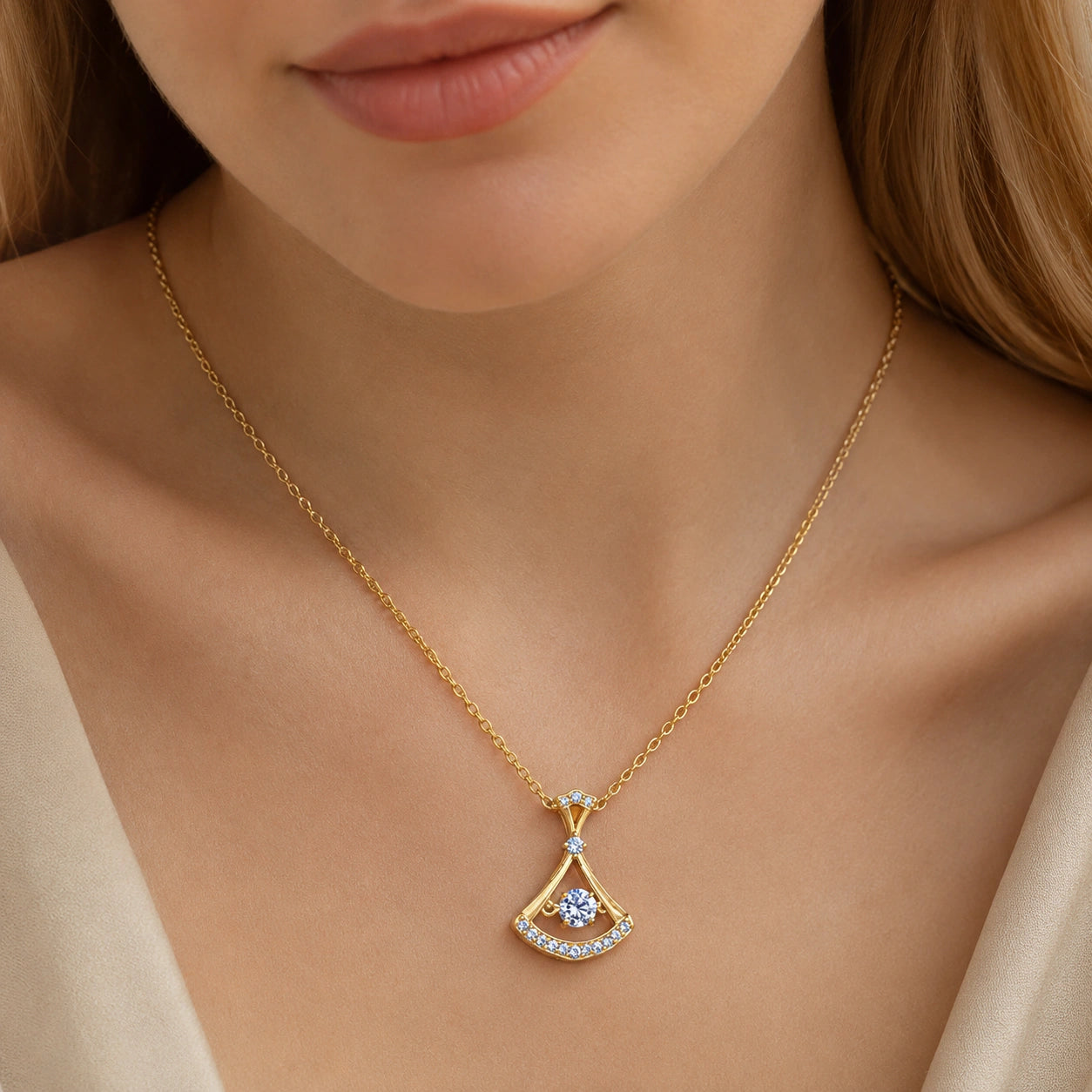 Gold fan-frame crystal necklace on a dark jewellery studio display