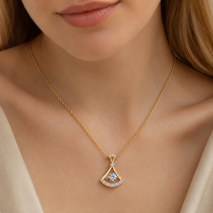 Gold fan-frame crystal necklace on a dark jewellery studio display