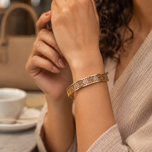 Angled view of the gold floral openwork hinged kada