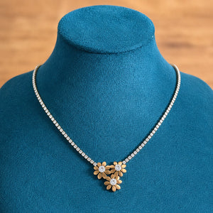 Gold floral trio necklace styled in an elegant jewellery flat lay