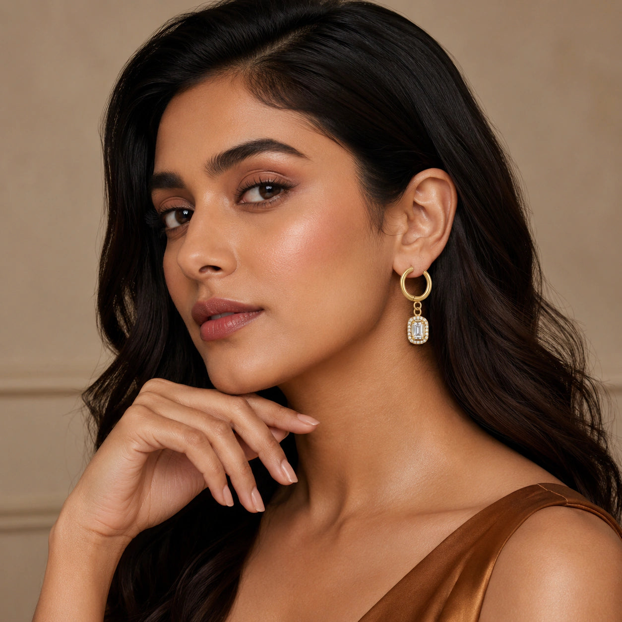 Gold green halo earring set on a dark jewellery studio display